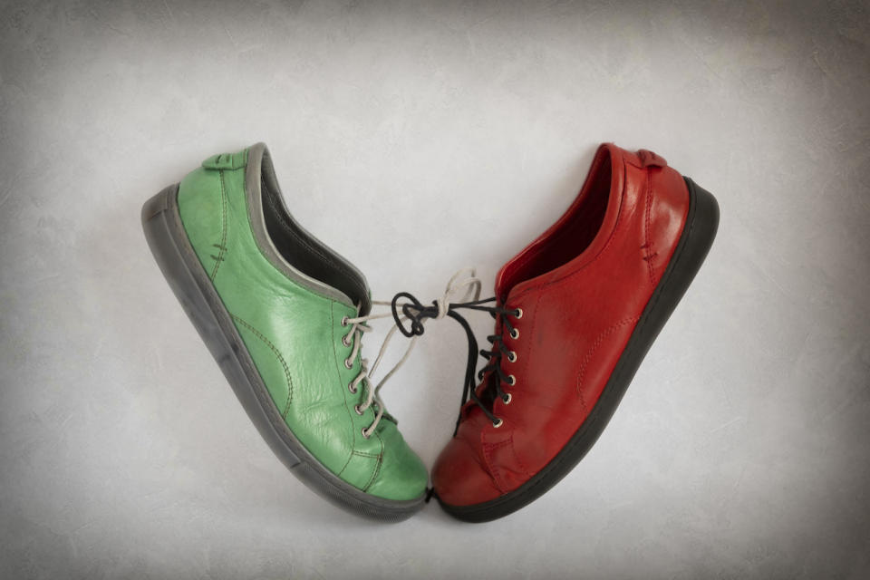 A red and a green shoe tied together