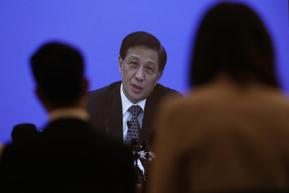 Zhang Yesui, a spokesman for the National People's Congress, is broadcast on a screen at a media center during a press conference on the eve of the annual legislature opening session in Beijing on Thursday, May 21, 2020. China's ceremonial parliament will consider legislation that could limit opposition activity in Hong Kong, the spokesperson said Thursday, appearing to confirm speculation that China will sidestep the territory's own legislative body in enacting legislation to crack down on activity Beijing considers subversive. (AP Photo/Mark Schiefelbein, Pool)