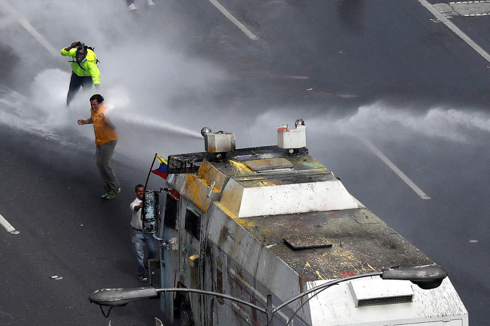 <p>Opposition Deputy Carlos Paparoni is hit by a jet of water during riots at a march to the state ombudsman’s office in Caracas, Venezuela, May 29, 2017. (Carlos Garcia Rawlins/Reuters) </p>