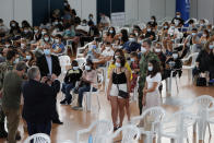 A family poses for a picture with Rear Admiral Henrique Gouveia e Melo at a vaccination center in Lisbon, Saturday, Sept. 11, 2021. As Portugal nears its goal of fully vaccinating 85% of the population against COVID-19 in nine months, other countries want to know how it was able to accomplish the feat. A lot of the credit is going to Gouveia e Melo. (AP Photo/Armando Franca)