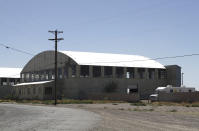 This Wednesday, May 22, 2019, photo shows a World War II-era bomber hanger in Deming, N.M. A surge of asylum-seeking families has been straining cities along the southern U.S. border for months, but now the issue is flowing into cities far from Mexico, where immigrants are being housed in an airplane hangar and rodeo fairgrounds and local authorities are struggling to keep up with the influx. (AP Photo/Cedar Attanasio)