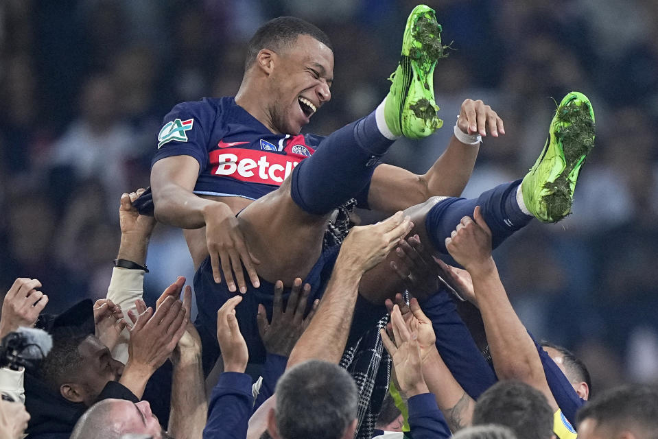 PSG's Kylian Mbappe is tossed into the air as he celebrates with teammates after the French Cup final soccer match between Lyon and PSG at the Pierre Mauroy stadium in Villeneuve d'Ascq, northern France, Saturday, May 25, 2024. PSG won the match 2-1. (AP Photo/Michel Euler)