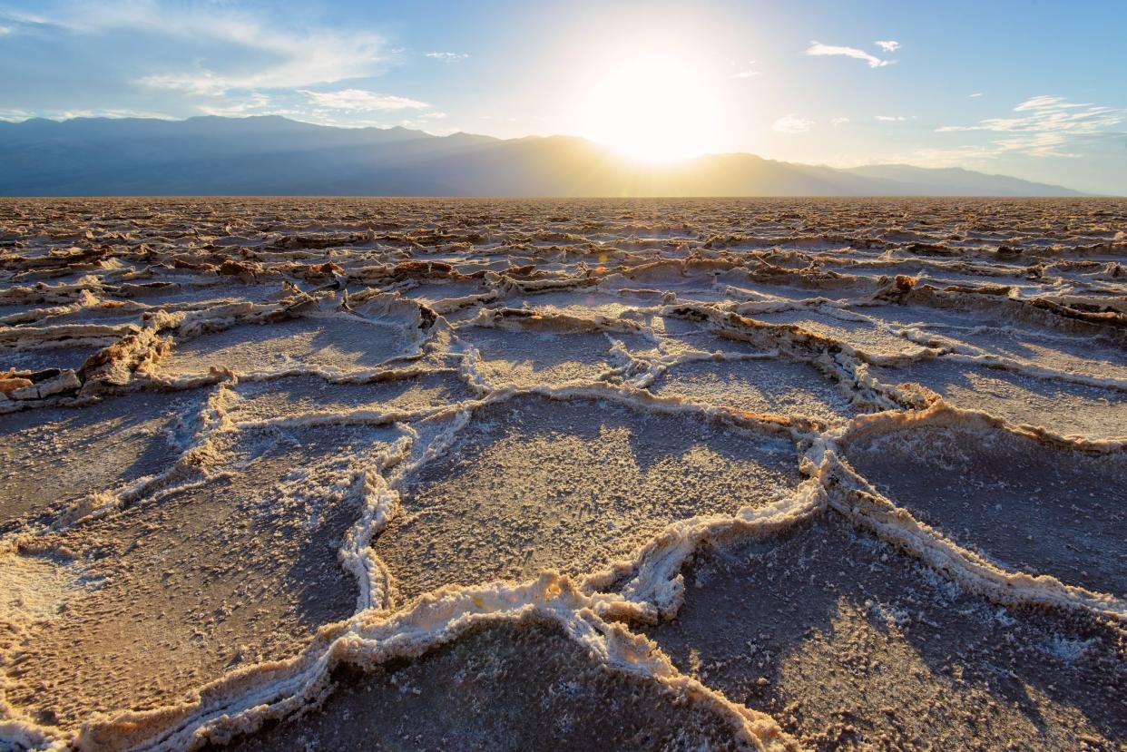 sunset over patterns on the salt flats of Badwater Basin - Death Valley National Park in California