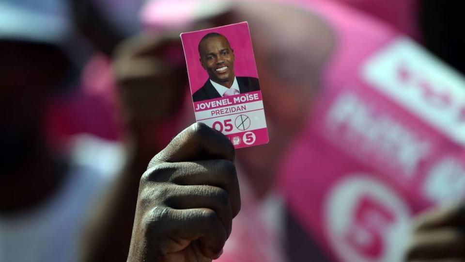 Un manifestante sostiene una foto del candidato presidencial Jovenel Moïse cerca de la sede del Consejo Electoral Provisional en Puerto Príncipe.