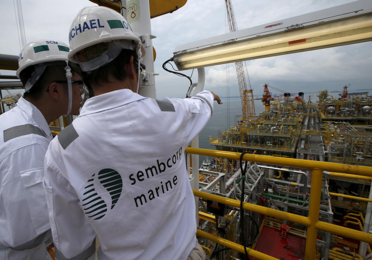 Sembcorp employees look at the modules on the main deck of Tullow Oil's newly completed Floating Production, Storage and Offloading vessel (FPSO) Prof. John Evans Atta Mills at Sembcorp Marine's Jurong Shipyard in Singapore January 20, 2016. Amid one of the deepest oil price crashes in history, Britain's Tullow Oil is sending one of the world's biggest floating deep-water oil production platforms to West Africa to pump crude for at least 20 years. Picture taken January 20, 2016.   REUTERS/Edgar Su