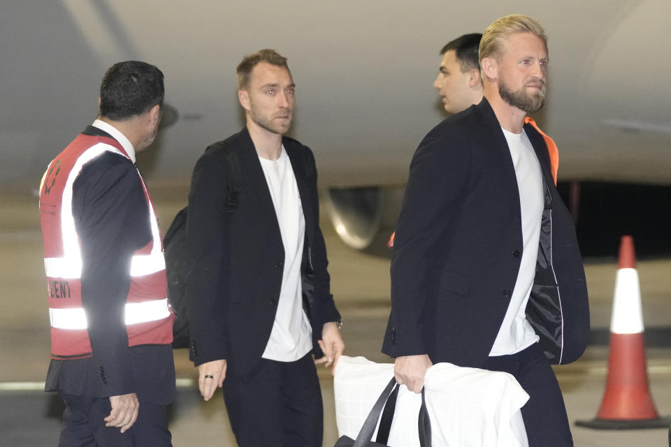 Kasper Schmeichel of the Denmark's national soccer team, right, arrives with teammate Christian Eriksen at Hamad International airport in Doha, Qatar, Tuesday, Nov. 15, 2022 ahead of the upcoming World Cup. Denmark will play their first match in the World Cup against Tunisia on Nov. 22. (AP Photo/Hassan Ammar)