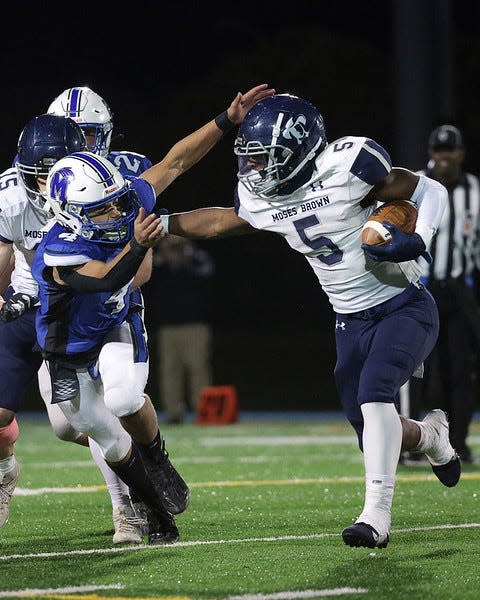 Moses Brown's Myles Craddock stiff-arms an Islanders defender during their game on Nov. 3 in Middletown.