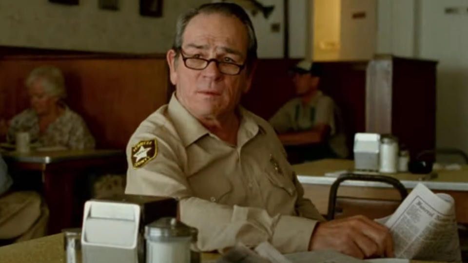 Tommy Lee Jones sits reading the paper in a diner in No Country For Old Men.