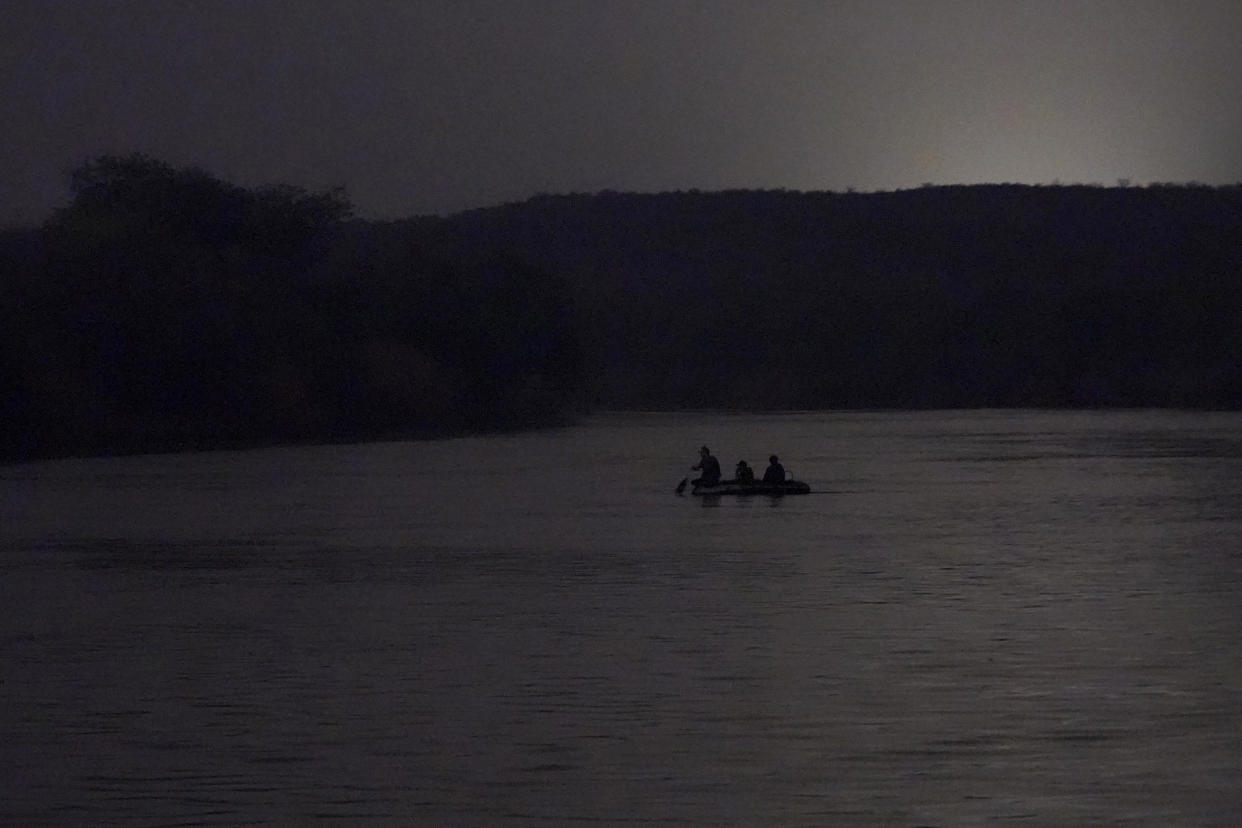 FILE - People cross the U.S.-Mexico border early March 24, 2021, in Roma, Texas. The Rio Grande Valley came alive each night with inflatable rafts carrying families across the meandering river. (AP Photo/Julio Cortez, File)