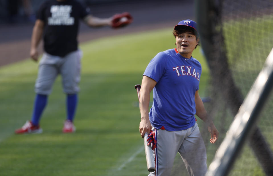 Texas Rangers left fielder Shin-Soo Choo reacts after avoiding a practice throw by shortstop Elvis Andrus as he warms up before a baseball game against the Colorado Rockies Saturday, Aug. 15, 2020, in Denver. (AP Photo/David Zalubowski)