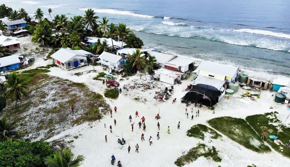 An aerial view shows community members playing volleyball on an area of reclaimed land, a countermeasure to the rising sea, next to the Pacific Ocean on November 23, 2019 in Funafuti, Tuvalu.