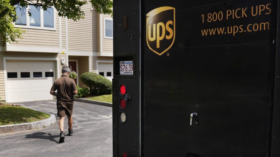 United Parcel Service deliveryman walks through a neighborhood while carrying packages to a home, Friday, June 30, 2023, in Haverhill, Mass. (AP Photo/Charles Krupa)