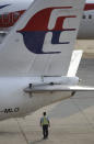 A ground staff member walks under a Malaysia Airlines plane at Kuala Lumpur International Airport in Sepang, Malaysia, Wednesday, March 12, 2014. The missing Malaysian jetliner may have attempted to turn back before it vanished from radar, but there is no evidence it reached the Strait of Malacca, Malaysia's air force chief said Wednesday, denying reported remarks he said otherwise. The statement suggested continued confusion over where the Boeing 777 might have ended up, more than four days after it disappeared en route to Beijing from Kuala Lumpur with 239 people on board. (AP Photo/Lai Seng Sin)