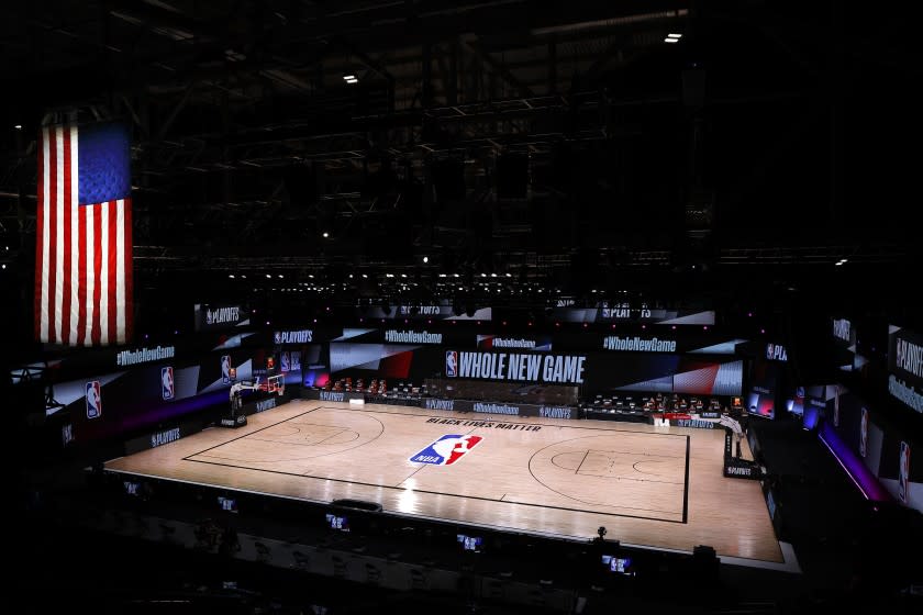 An empty court and bench are shown following the scheduled start time in of Game 5 of an NBA basketball first-round playoff series, Wednesday, Aug. 26, 2020, in Lake Buena Vista, Fla. NBA players made their strongest statement yet against racial injustice Wednesday when the Milwaukee Bucks didn't take the floor for their playoff game against the Orlando Magic. (Kevin C. Cox/Pool Photo via AP)