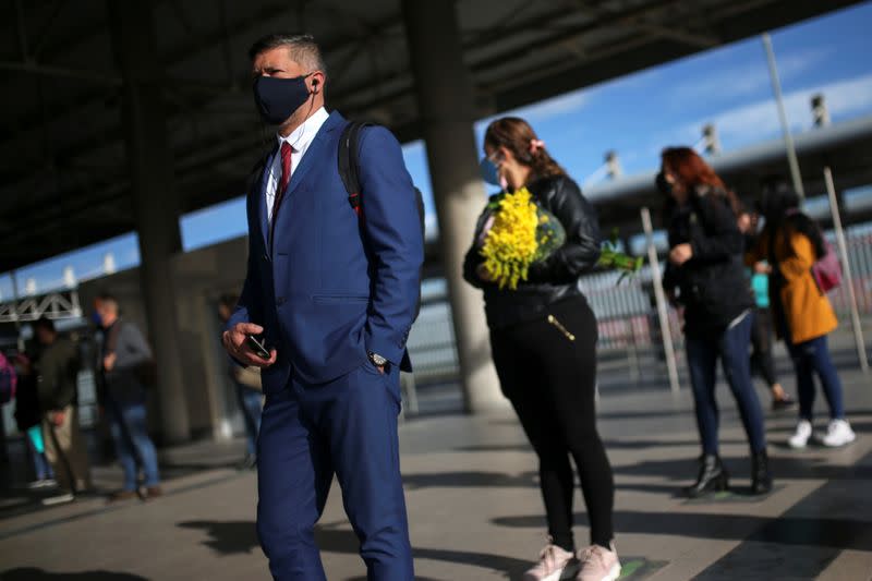 IMAGEN DE ARCHIVO. Personas utilizando mascarillas debido al brote de coronavirus, mantiene distancia social mientras esperan buses del transporte público, en Bogotá, Colombia