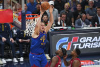 Denver Nuggets center Nikola Jokic, left, passes the ball next to Miami Heat forward Jimmy Butler, center, during the first half of Game 1 of basketball's NBA Finals, Thursday, June 1, 2023, in Denver. (AP Photo/Jack Dempsey)
