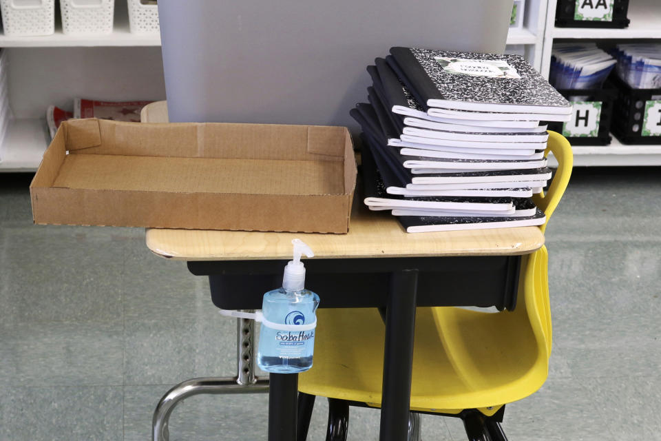 Hand sanitizer is attached to a desk in a classroom at Aikahi Elementary School in Kailua, Hawaii, Tuesday, July 28, 2020. While Hawaii has one of the lowest rates of cases per capita in the country and many of its schools have open-air campuses, the challenges of returning kids full time to classrooms may still be insurmountable. (AP Photo/Jennifer Sinco Kelleher)