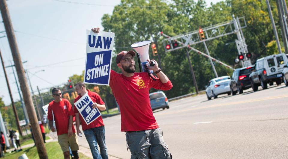 UAW Local 1753 member Jean Duchemin plays the song "Which Side Are You On?" thru a megaphone as he and fellow workers picket outside of the GM Lansing Redistribution Center, Friday, Sept. 22, 2023.