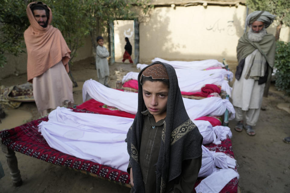 Afghan men and a boy stand near the bodies of people killed in an earthquake in Gayan village, Paktika province, Afghanistan, June 23, 2022. / Credit: Ebrahim Noroozi/AP