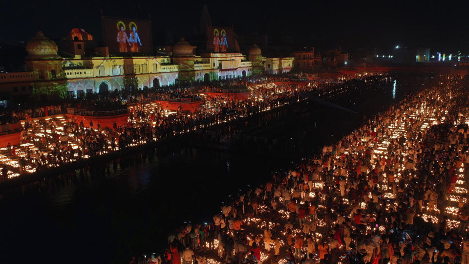 People light lamps on the banks of the river Saryu in Ayodhya, India, Wednesday, Nov. 3, 2021. Over 900,000 earthen lamps were lit and were kept burning for 45 minutes as the north Indian city of Ayodhya retained its Guinness World Record for lighting oil lamps as part of the Diwali celebration – the Hindu festival of lights. (AP Photo/Rajesh Kumar Singh)