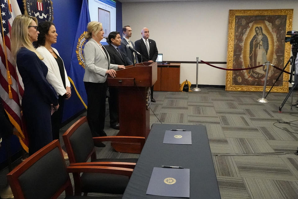 Kristi Koons Johnson, Assistant Director in Charge of the FBI's Los Angeles Field Office, at podium, hosts a repatriation ceremony with officials from the United States Department of State, the United States Attorney's Office, the Consul General for the Peruvian Consulate in Los Angeles and the University of California at Los Angeles (UCLA) to return cultural pieces, some of which are 400 years old, following investigations by the FBI's Art Crime Tea at the FBI headquarters in Los Angeles Friday, April 22, 2022. The "Virgin of Guadalupe" oil painting, right, was stolen from the Santiago Apostle Church, also known as "Saint James Apostle," in Ollantaytambo, Peru, with six other paintings. (AP Photo/Damian Dovarganes)