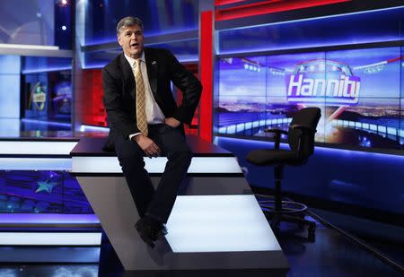 Fox News Channel anchor Sean Hannity poses for photographs as he sits on the set of his show "Hannity" at the Fox News Channel's studios in New York City, October 28, 2014. REUTERS/Mike Segar