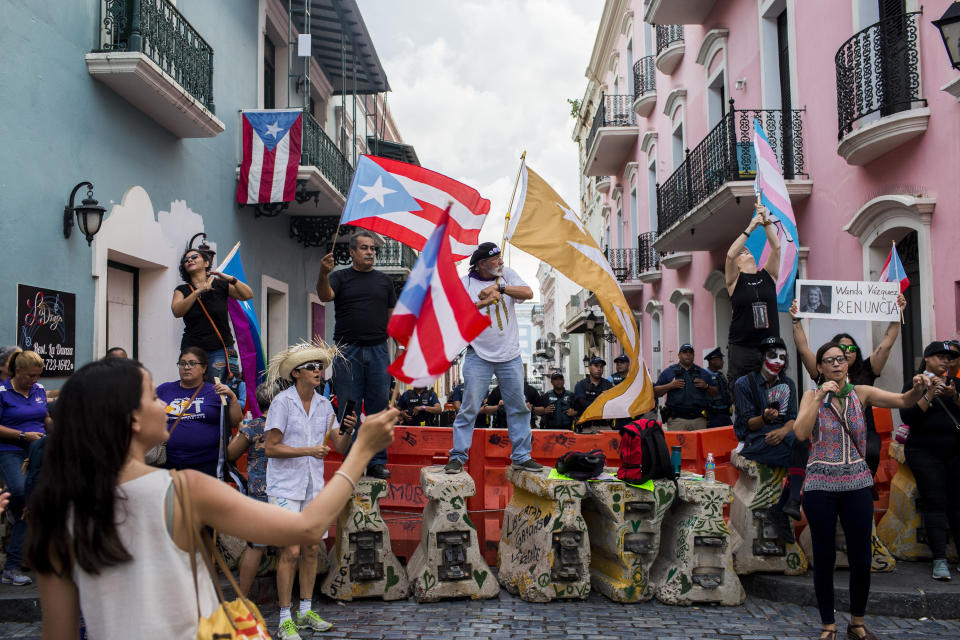 Protesters gather outside the government mansion La Fortaleza in San Juan, Puerto Rico, Wednesday, Aug. 7, 2019, calling for the removal of the island's newly sworn-in governor. Justice Secretary Wanda Vazquez took the oath of office early Wednesday evening at the Puerto Rican Supreme Court, which earlier in the day ruled that Pedro Pierluisi's swearing in last week was unconstitutional. (AP Photo/Dennis M. Rivera Pichardo)