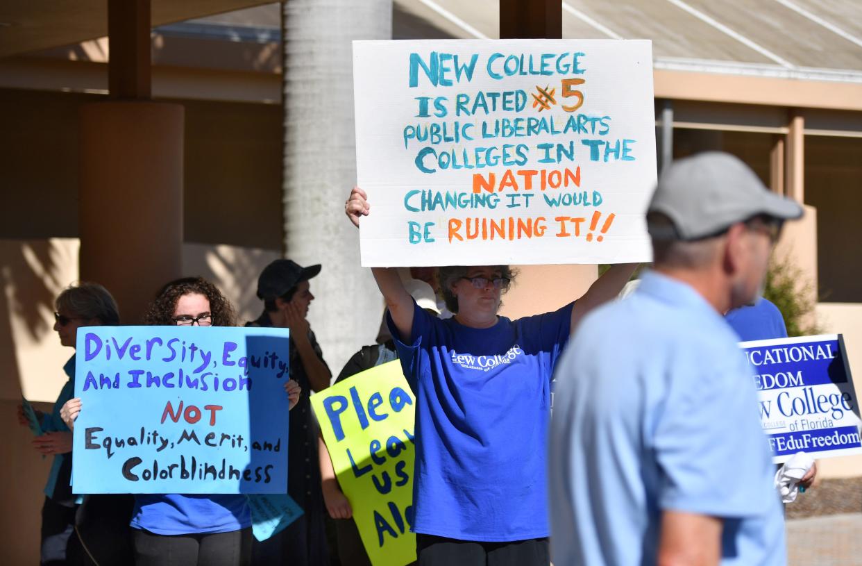 Supporters of New College of Florida hold up signs outside the Sarasota County Administration Building Thursday, Jan. 12, 2023, before the start of the regular meeting of the Sarasota legislative delegation. 