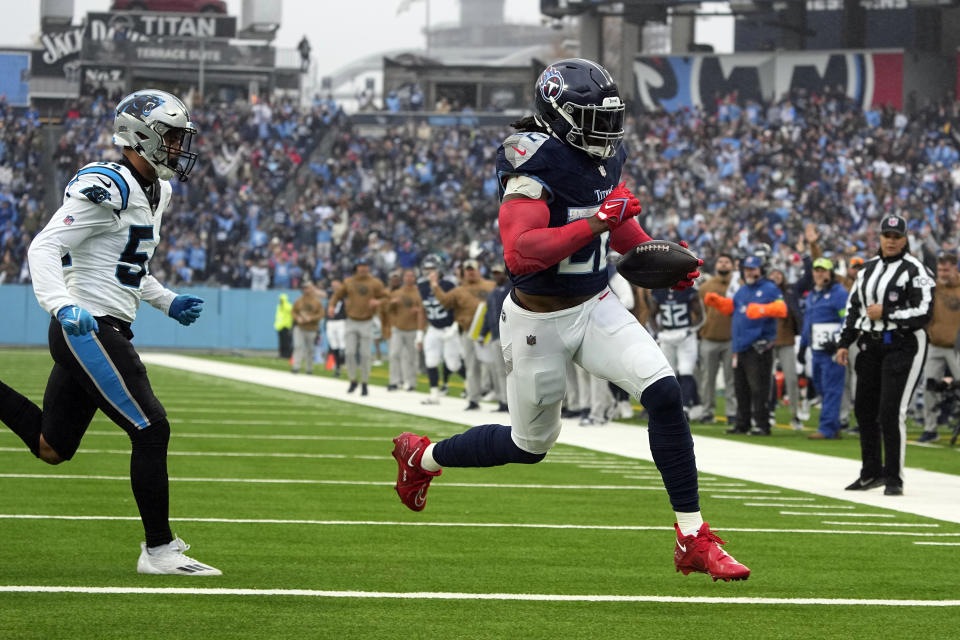 Tennessee Titans running back Derrick Henry, right, scores his second touchdown of the game ahead of Carolina Panthers linebacker Kamu Grugier-Hill (54) during the first half of an NFL football game Sunday, Nov. 26, 2023, in Nashville, Tenn. (AP Photo/George Walker IV)