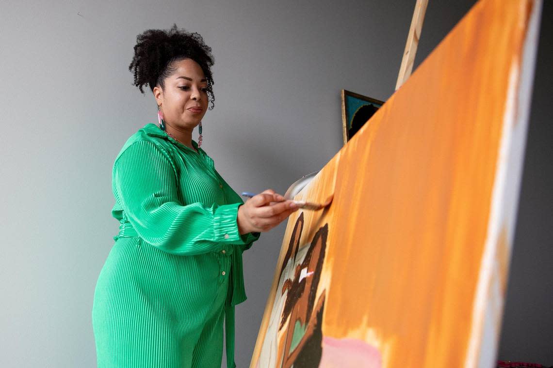 Kansas City artist Christa Rice works on her latest painting of three generations of Black women doing hair. Kylie Graham/Special to The Star