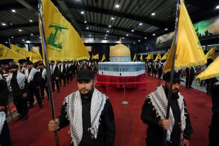 Hezbollah members carry Hezbollah flags as they stand in front of a replica of the Dome of the Rock during a rally marking Al-Quds day in Beirut's southern suburbs, Lebanon June 23, 2017. REUTERS/Aziz Taher