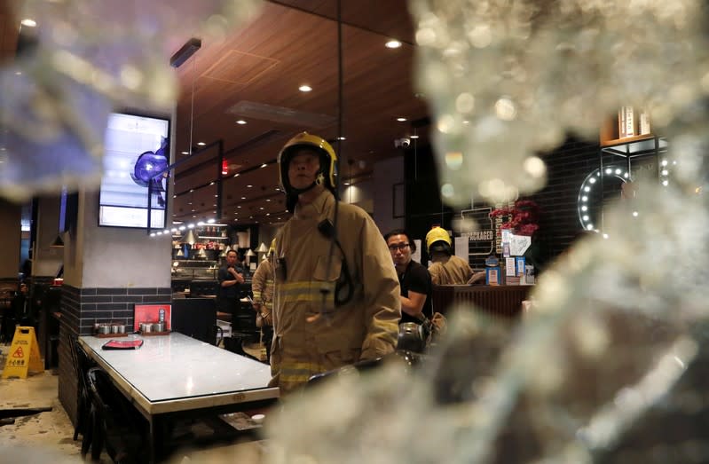 A fire fighter stands inside a restaurant vandalised during an anti-government demonstration in Hong Kong