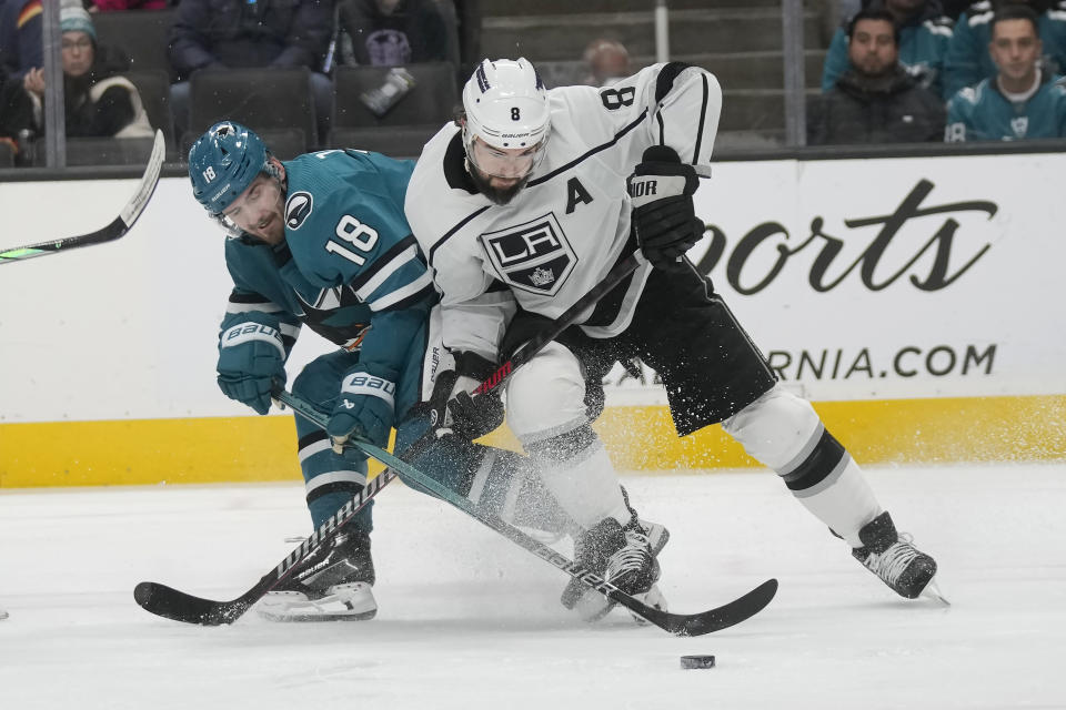 San Jose Sharks right wing Filip Zadina (18) reaches for the puck next to Los Angeles Kings defenseman Drew Doughty (8) during the first period of an NHL hockey game in San Jose, Calif., Tuesday, Dec. 19, 2023. (AP Photo/Jeff Chiu)