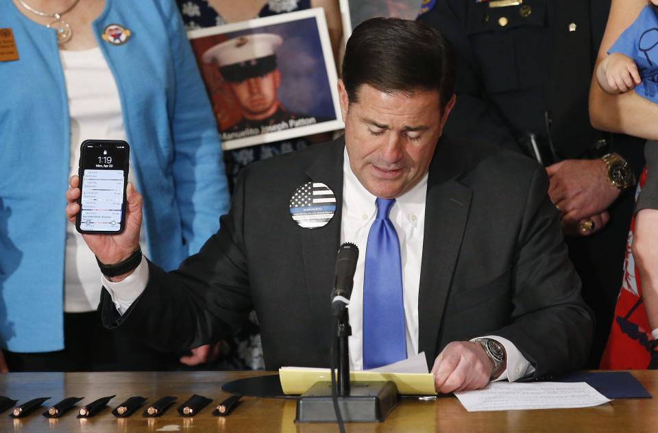 Arizona Republican Gov. Doug Ducey speaks prior to signing into law a distracted driving bill at a ceremony at the Arizona Capitol Monday, April 22, 2019, in Phoenix. Arizona becomes the 48th state to ban texting and the 18th to ban any hand-held phone use while driving. Officers can begin issuing warnings immediately and can write tickets in 2021. (AP Photo/Ross D. Franklin)