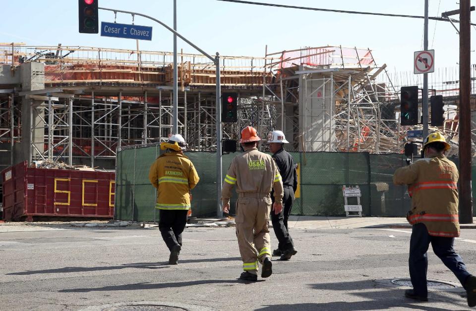 Los Angeles Firefighters arrive at the site of a parking structure under construction that collapsed Friday March 28, 2014 in Los Angeles. A section of the parking structure under collapsed, but authorities say it appears no one was hurt. (AP Photo/Nick Ut)