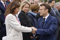 FILE - France's President Emmanuel Macron, right, shakes hands with Paris mayor, Anne Hidalgo, during a ceremony to mark the 77th anniversary of the end of World War II, Sunday, May 8, 2021, in Paris. Paris mayor Anne Hidalgo said Tuesday April 23, 2024 she was confident water quality will be up to the Olympics standards this summer _ and that she'll be able to prove it by swimming there, possibly alongside President Emmanuel Macron. (Ludovic Marin, Pool via AP, File)