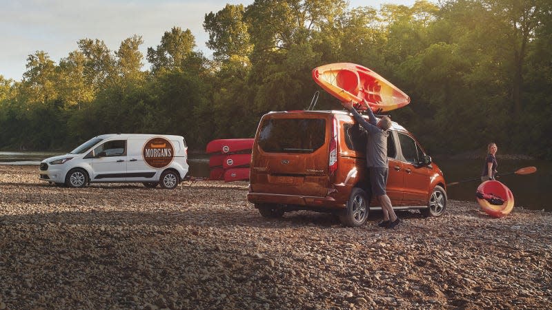 A photo of a Ford Transit Connect van with a kayak on its roof. 