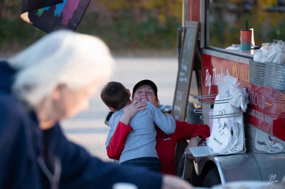 Terrie Chasse, a volunteer with Red's Good Vibes, is greeted by a little boy and thanked for a free meal.