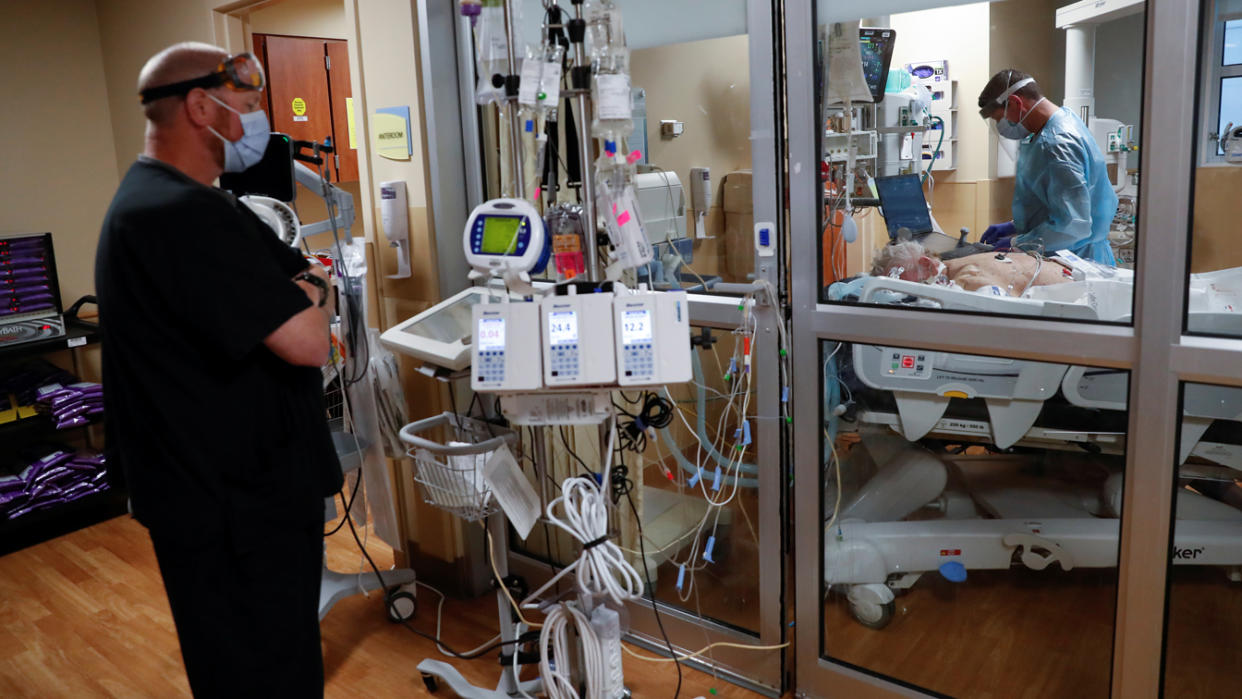 A critical care respiratory therapist works with a coronavirus disease (COVID-19) positive patient in the intensive care unit (ICU) at Sarasota Memorial Hospital in Sarasota, Florida, February 11, 2021. (Shannon Stapleton/Reuters)