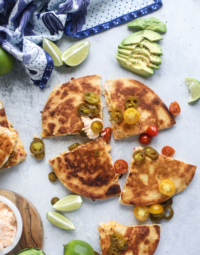 pimento cheese chicken quesadillas with cherry tomatoes and pickled jalepenos on surface