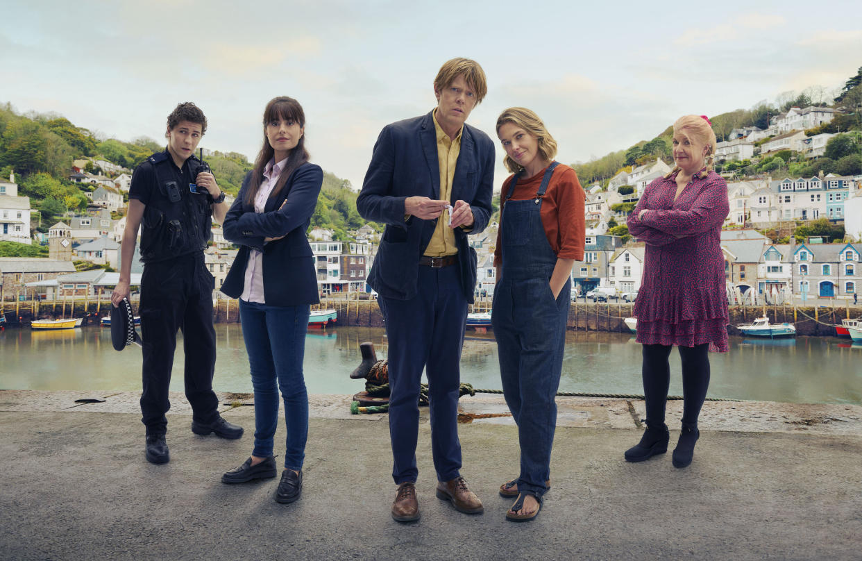  The cast of Beyond Paradise in a group shot on the seafront of Shipton Abbott: Dylan Llewellyn as PC Kelby Hartford, Zahra Ahmadi as DS Esther Williams, Kris Marshall as DI Humphrey Goodman, Sally Bretton as Martha Lloyd and Felicity Montagu as Margo Martins 