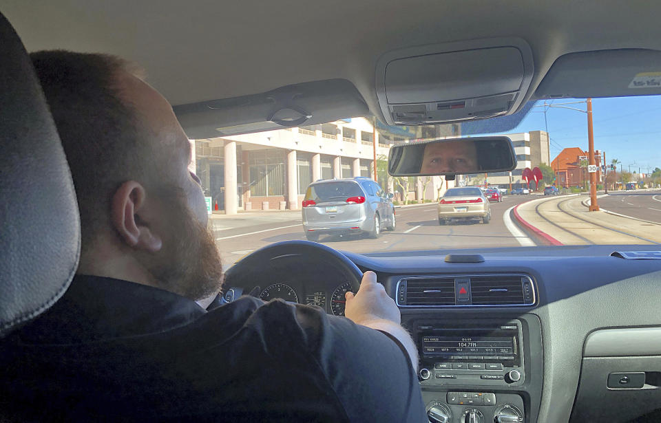 Uber driver David Kueneman, 34, talks Thursday, Dec. 19, 2019, about a new increase being imposed by Phoenix starting Feb. 1, 2020 on ride-hailing companies offering curbside service at Phoenix Sky Harbor International Airport. (AP Photo/Anita Snow)