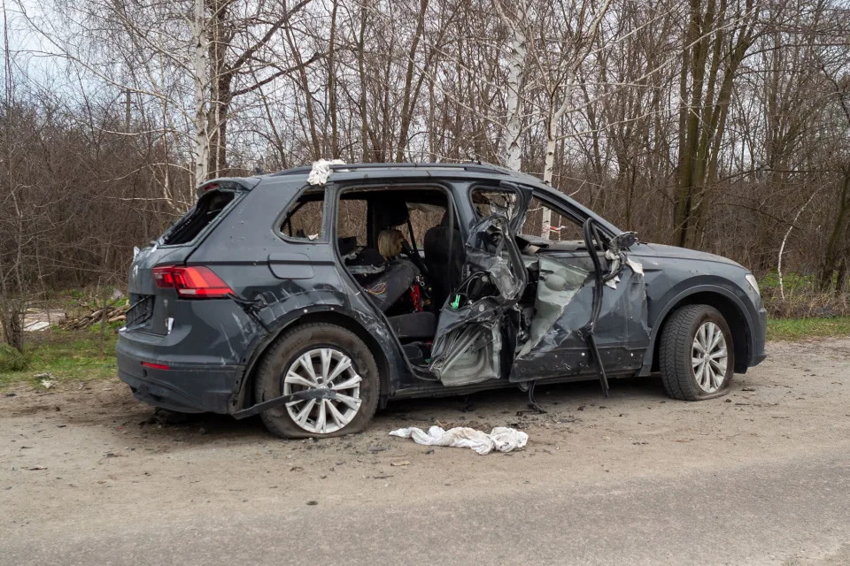 A damaged car is left by the roadside in the town of Havronshchyna.  (Mo Abbas / NBC News)