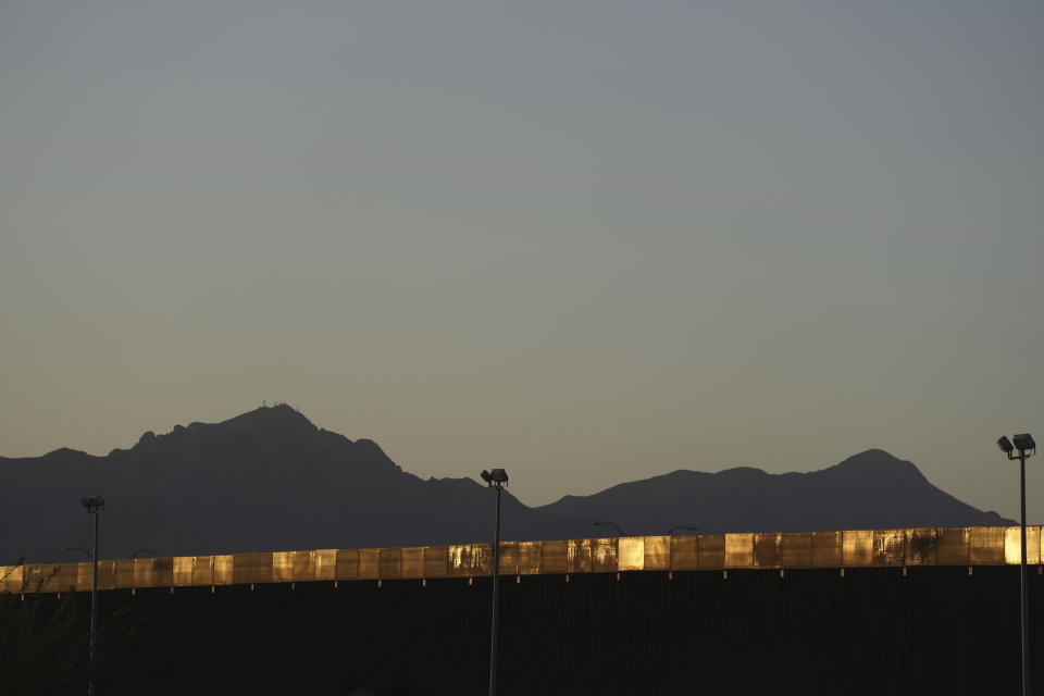 The afternoon sun lights up the fence on the U.S. border, seen from Ciudad Juarez, Mexico, Wednesday, March 29, 2023, a day after dozens of migrants died in a fire at a migrant detention center in Ciudad Juarez. (AP Photo/Fernando Llano)