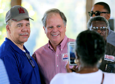 Democratic Alabama U.S. Senate candidate Doug Jones poses for pictures as he greets supporters while campaigning at an outdoor festival in Grove Hill, Alabama. REUTERS/Mike Kittrell