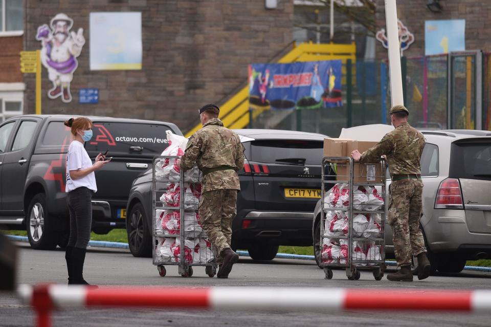 An NHS worker speaks with soldiers as they carry supplies at Pontin's Southport Holiday Park, north of Liverpool on November 5, 2020, prior to assisting in a mass and rapid testing pilot scheme for the novel coronavirus COVID-19, in Liverpool. - Prime Minister Boris Johnson promised 