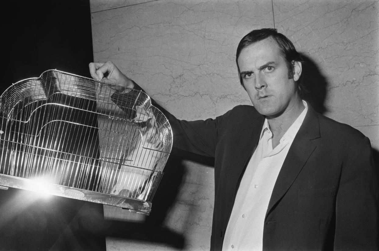 English comedian and actor John Cleese with a dead parrot soft toy, in reference to the famous Monty Python sketch, UK, 1971. (Photo by Evening Standard/Hulton Archive/Getty Images)