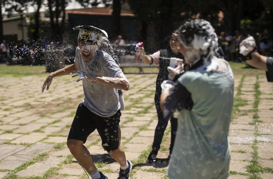 Students graduating from the General Las Heras elementary school, where soccer player Lionel Messi also attended, play with foam on their last day in Rosario, Argentina, Wednesday, Dec. 14, 2022. (AP Photo/Rodrigo Abd)
