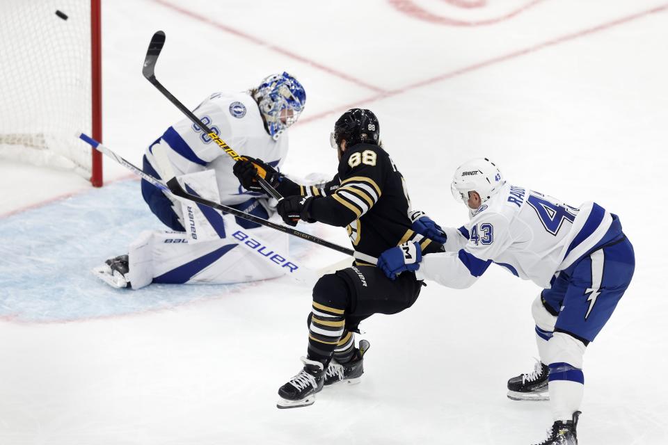 Boston Bruins' David Pastrnak, center, scores on Tampa Bay Lightning's Andrei Vasilevskiy left, as Darren Raddysh (43) defends during the second period of an NHL hockey game, Saturday, Jan. 6, 2024, in Boston. (AP Photo/Michael Dwyer)