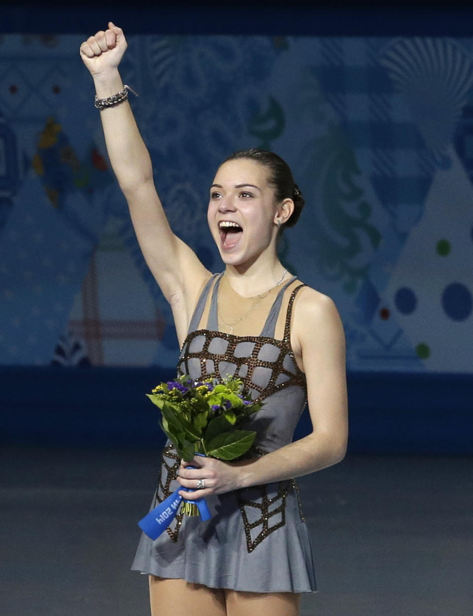 Adelina Sotnikova of Russia celebrates on the podium as she celebrates placing first during the flower ceremony for the women's free skate figure skating final at the Iceberg Skating Palace during the 2014 Winter Olympics, Thursday, Feb. 20, 2014, in Sochi, Russia. (AP Photo/Darron Cummings)